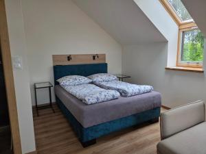 a bedroom with a bed with a blue headboard at Via Mare in Jantar