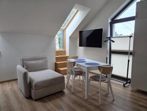 a small living room with a table and a chair at Via Mare in Jantar