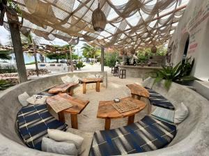 a patio with tables and chairs under a roof at Lõst Soles Lodge in Jambiani