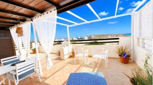 a balcony with a table and chairs and a view of the ocean at Attico Residence Costa do Sol in Sal Rei