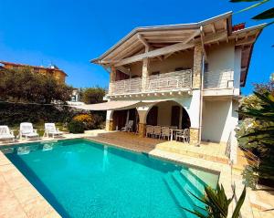 a house with a swimming pool in front of it at Villa Bocciolo, piscina, giardino, vasca idromassaggio in Manerba del Garda