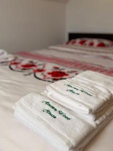 a group of white towels sitting on a bed at Apuseni Wood House in Mătişeşti