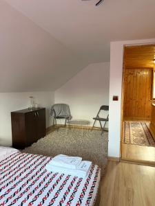a bedroom with a bed and a table and chairs at Apuseni Wood House in Mătişeşti
