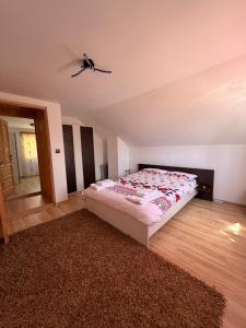 a bedroom with a bed and a ceiling fan at Apuseni Wood House in Mătişeşti