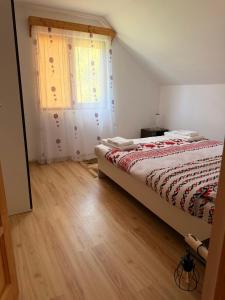 a bedroom with a bed and a window at Apuseni Wood House in Mătişeşti