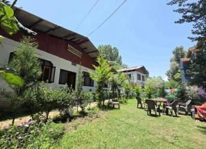 a building with chairs and a table in the yard at Alamdar guest house in Srinagar