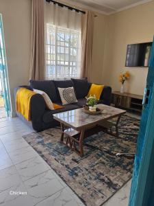 a living room with a couch and a coffee table at LaDee Homes Cozy 1 bedroom in Kakamega - Old National Housing Estate in Kakamega
