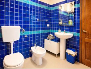 a blue tiled bathroom with a toilet and a sink at Attico Residence Costa do Sol in Sal Rei +43 photos