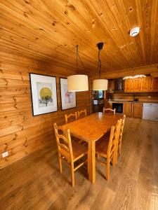 a dining room with a wooden table and chairs at Chalet O Refúgio 2 in Penhas da Saúde