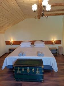 a bedroom with a bed with a blue suitcase at Стаи за гости "Архангел Михаил" in Kostenets