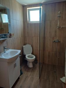 a bathroom with a toilet and a sink and a shower at Стаи за гости "Архангел Михаил" in Kostenets +36 photos