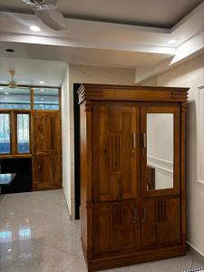 a large wooden cabinet in a room at 1Rk Karwar downtown Studio in Kārwār