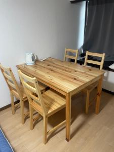 a wooden table and chairs with a wooden table and chairs at 大阪魔力民泊·岸里 in Osaka