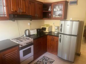a kitchen with a white refrigerator and wooden cabinets at Kalan Digana in Digana