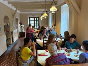 a group of people sitting at tables in a restaurant at Govinda in Pontinvrea