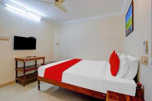 a bedroom with a bed and a tv on a wall at Hotel O Le Fort in Trivandrum