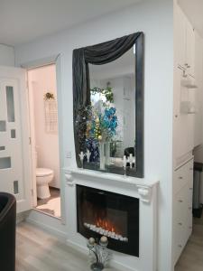 a living room with a fireplace and a mirror at Duplex Marquis in Braşov +50 photos