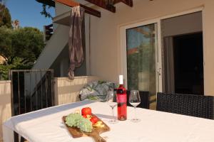 a table with a plate of food and wine glasses at Apartmani Štambuk in Jelsa
