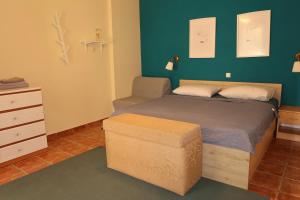 a small bedroom with a bed and a ottoman at Apartmani Štambuk in Jelsa