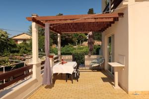 a patio with a table and awning on a house at Apartmani Štambuk in Jelsa