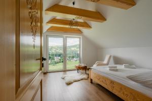 a bedroom with a bed and a large window at Echo Gorców in Mszana Górna