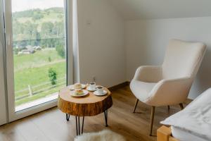 a room with a coffee table and a chair and a window at Echo Gorców in Mszana Górna +55 photos