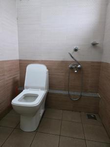 a bathroom with a toilet and a shower at Barza Inn in Kakkanad +4 photos