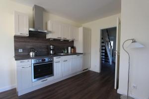 a kitchen with white cabinets and a stove at Noor-OG-mit-Studio-Nr-4 in Haby