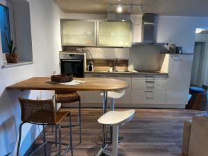 a kitchen with a wooden table and chairs at Wohnung mit Terrasse in Hirschaid