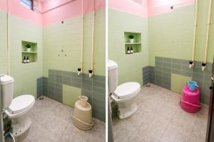 two toilets in a bathroom with green and pink tiles at Mysore rooms- sgh in Mysore