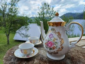 a tea pot and two cups on a table at Djedova nova kuca in Žabljak