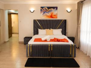 a bedroom with a large bed with a large headboard at Lakeview 3BR Apartment Nakuru CBD in Nakuru +10 photos
