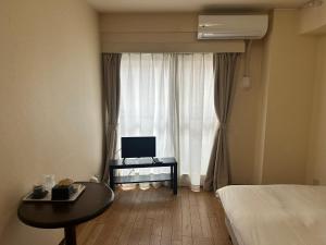a bedroom with a bed and a desk and a window at ACE INN Itabashi in Tokyo