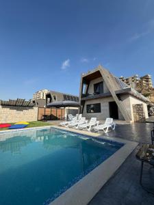 a house with a swimming pool next to a building at The Skyloft Tarchich - Panoramic Mountain Escapes in Aswāq aş Şafşāf