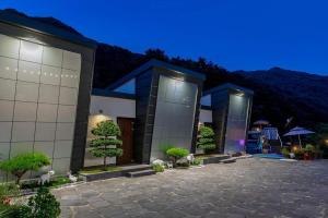 a building with some trees in front of it at Hadong Cloud Hill Pension in Hadong