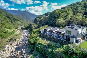 a house on a hill next to a river at Hadong Cloud Hill Pension in Hadong