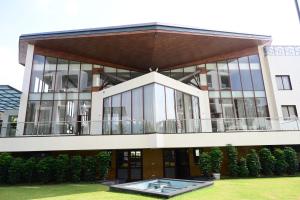 a large building with glass windows and a courtyard at IJ Crowne in Mysore
