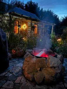 a fire pit in front of a house at night at The Karal cabin in Canterbury