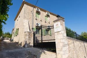 an old stone building with a black gate at Dervisia Stonehouse 4 in Lazaráta +28 photos