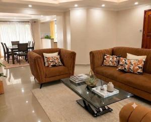 a living room with two couches and a table at Lakeview 3BR Apartment Nakuru CBD in Nakuru