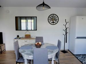 a kitchen with a table with chairs and a white refrigerator at Gîte coté Jardin in Isles-sur-Suippe