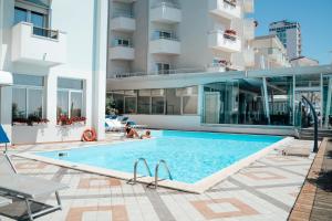 a swimming pool in front of a building at Hotel Niagara in Lido di Jesolo