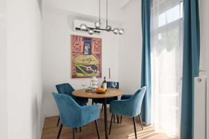 a dining room with a table and blue chairs at Chic 2BR Loft Steps from Great Synagogue Budapest in Budapest