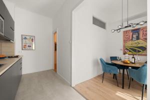 a kitchen and dining room with a table and chairs at Chic 2BR Loft Steps from Great Synagogue Budapest in Budapest
