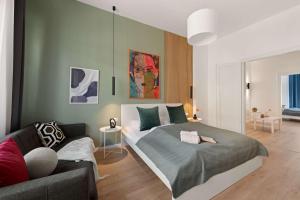a bedroom with a bed and a couch at Chic 2BR Loft Steps from Great Synagogue Budapest in Budapest +38 photos