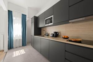 a kitchen with black cabinets and a counter top at Chic 2BR Loft Steps from Great Synagogue Budapest in Budapest