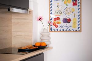 a vase with a flower and a plate of fruit on a kitchen counter at Chic 2BR Loft Steps from Great Synagogue Budapest in Budapest