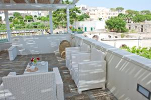 a row of white chairs and a table on a balcony at Corte della Luce in Ugento