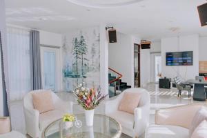 a living room with white chairs and a glass table at villa Trung Nghĩa 5 in Da Lat
