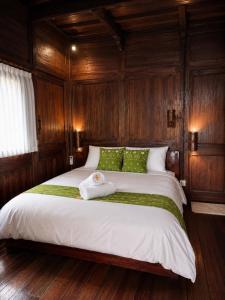 a bedroom with a large bed with wooden walls at Villa Hola Agung in Karangasem